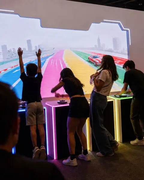 Players with their arms up at a racing minigame